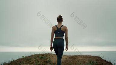 年轻的女运动员爬<strong>山顶</strong>回来视图运动女孩走海滩山
